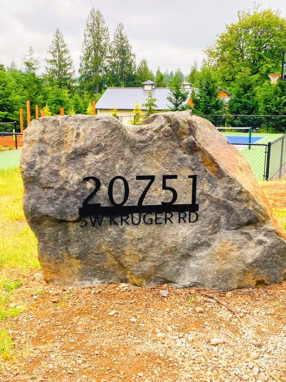 The metal address sign mounted on stone.
