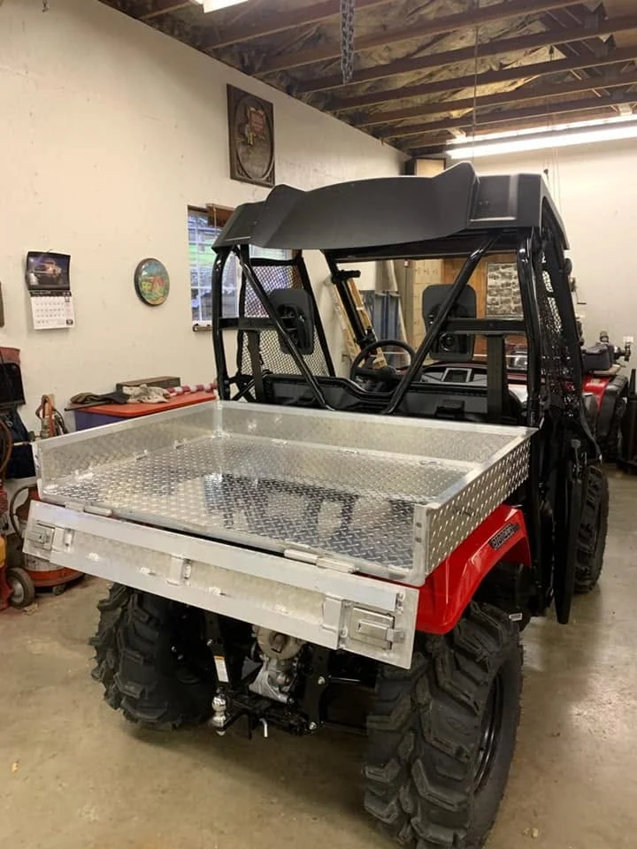 The UTV bed with its rear gate open.