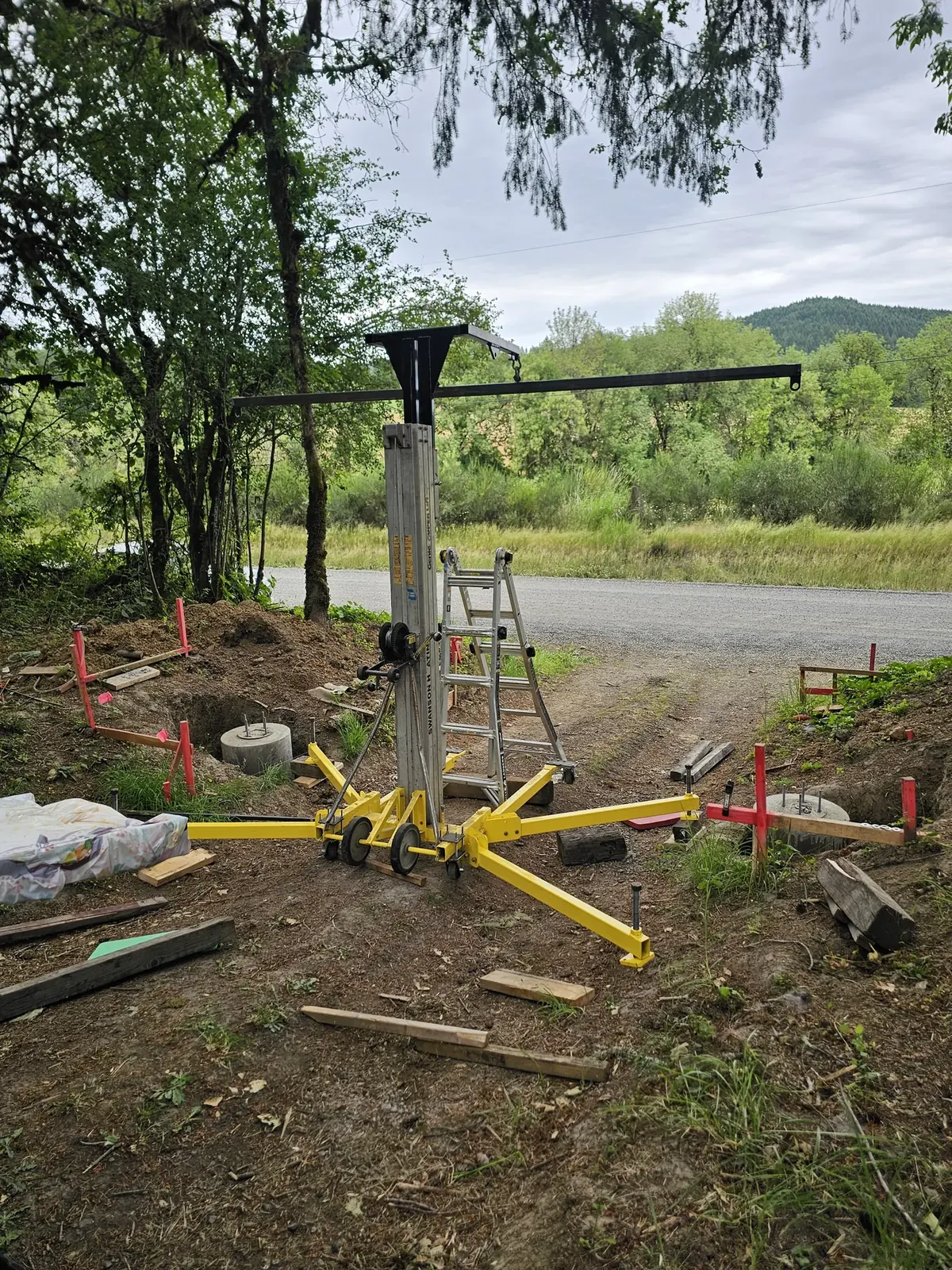 A portable lift and ladder at the cemetery entrance during sign installation.