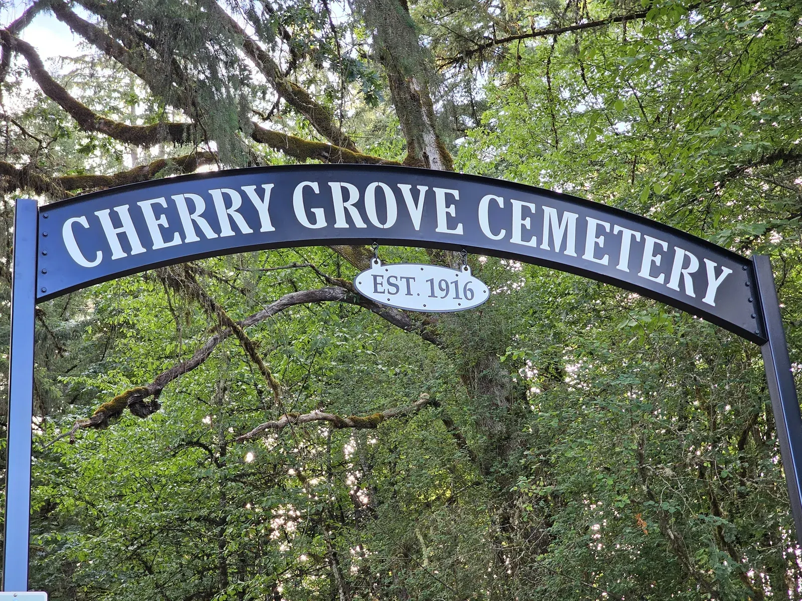 Close view of the Cherry Grove Cemetery lettering and the oval establishment-date plate beneath it.