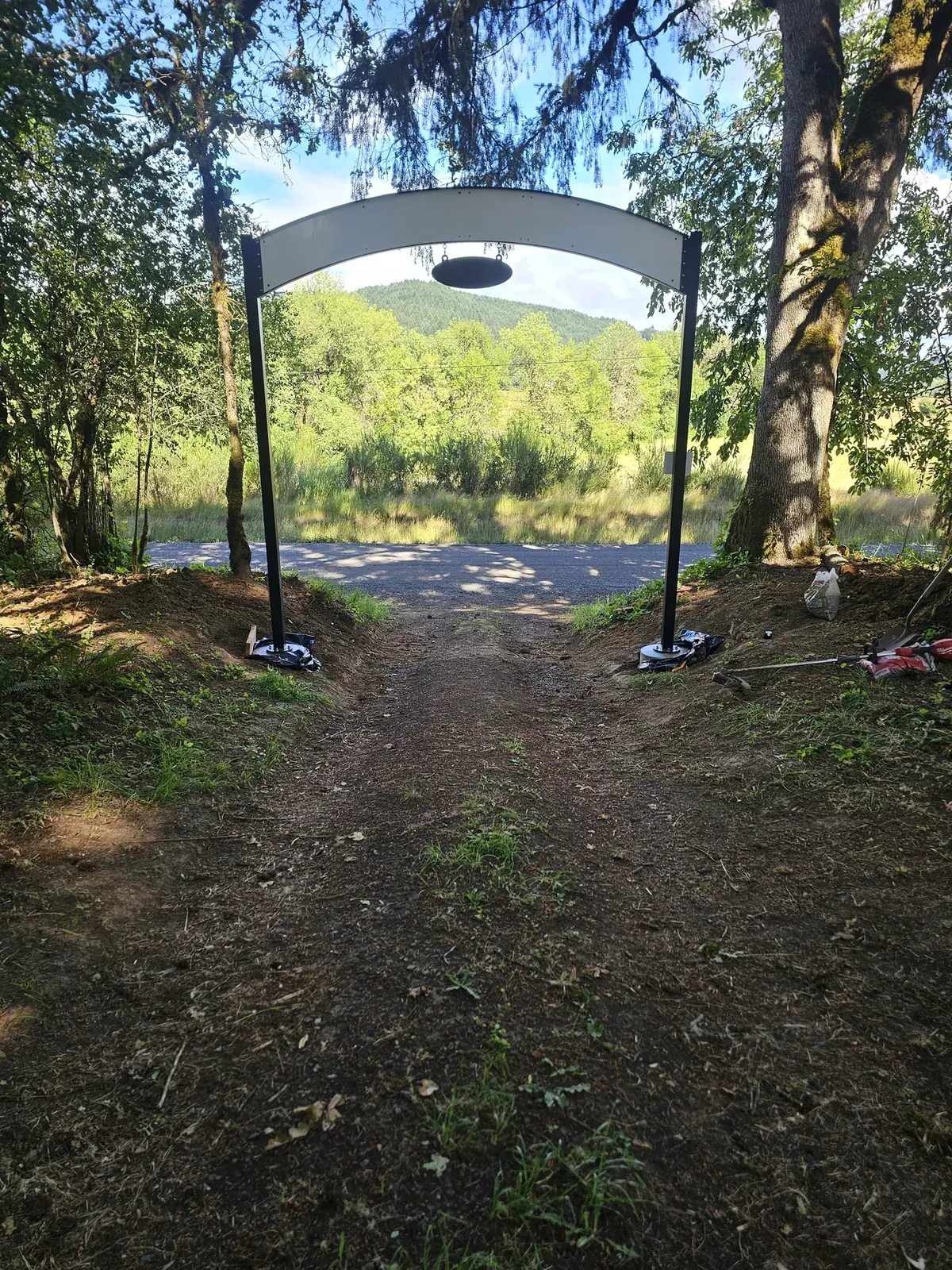 The back of the completed entrance sign, with its light backing panel, viewed toward the road.
