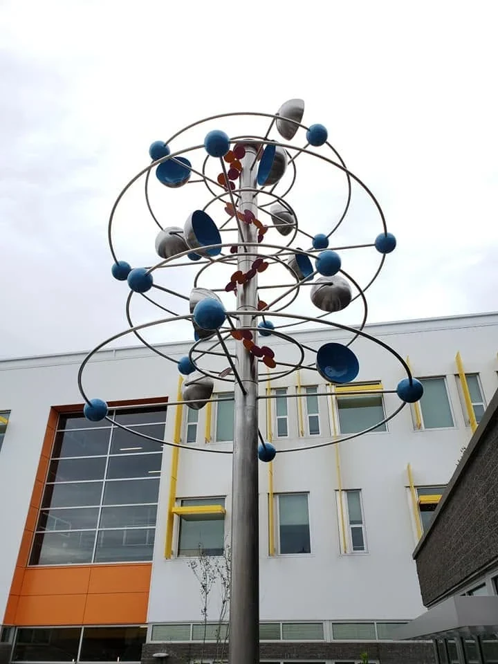 Upward view of the Carbon Atom Whirligig showing the central support, rings, blue spheres and cups.