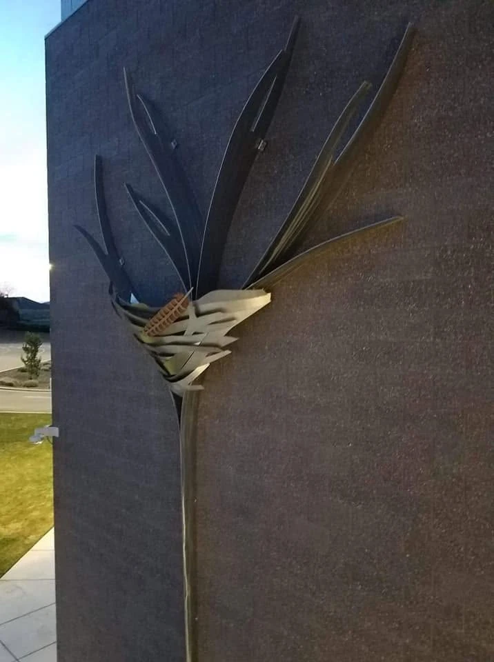Fledge, designed by Anne Storrs and fabricated by Western Iron Works, on the brick wall at Desert Hills Middle School.