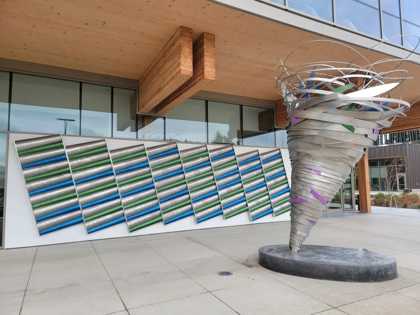 Spiral metal sculpture and patterned blue and green wall outside Hidden Creek Community Center.