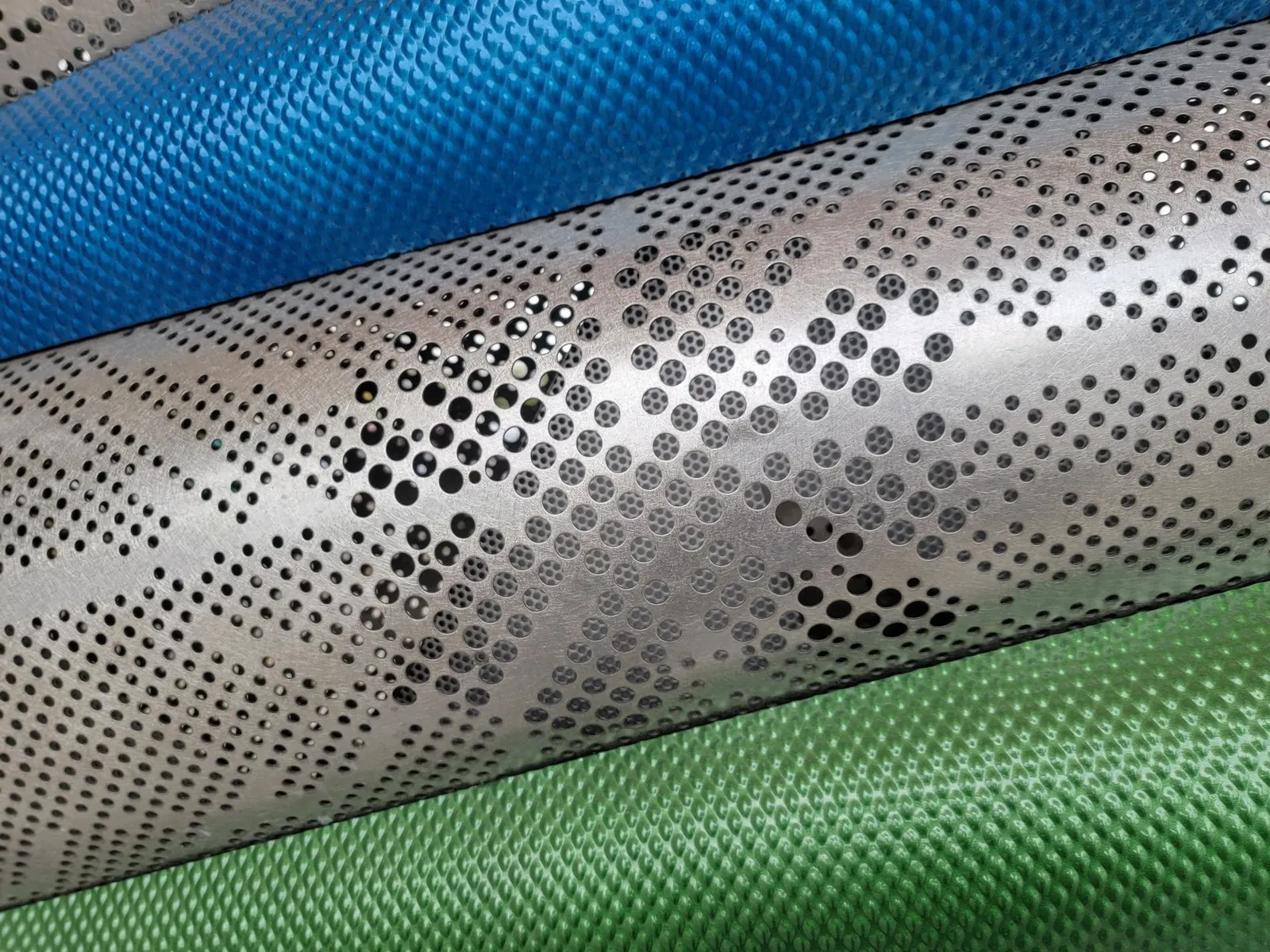 Polished triangles show through the painted, perforated forms.