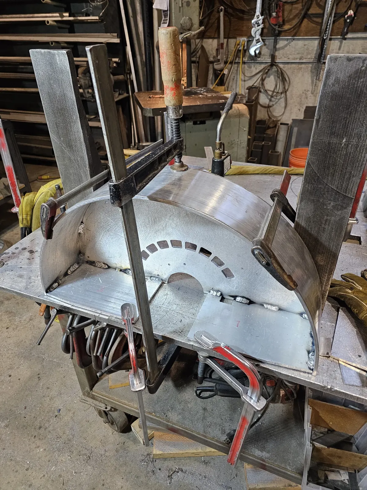 An aluminum base half held in clamps during fit-up in the WIW shop.
