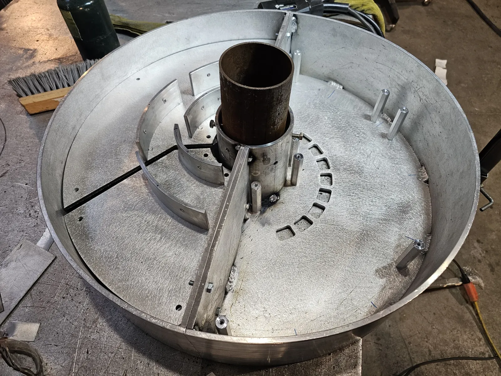 Top view inside the assembled aluminum base, showing the center opening, internal brackets and circular pattern of openings.