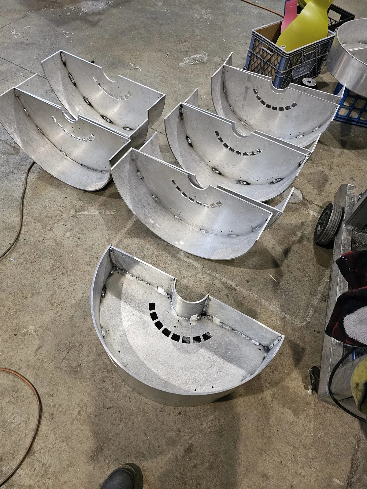 A row of fabricated aluminum base halves arranged in the WIW shop.