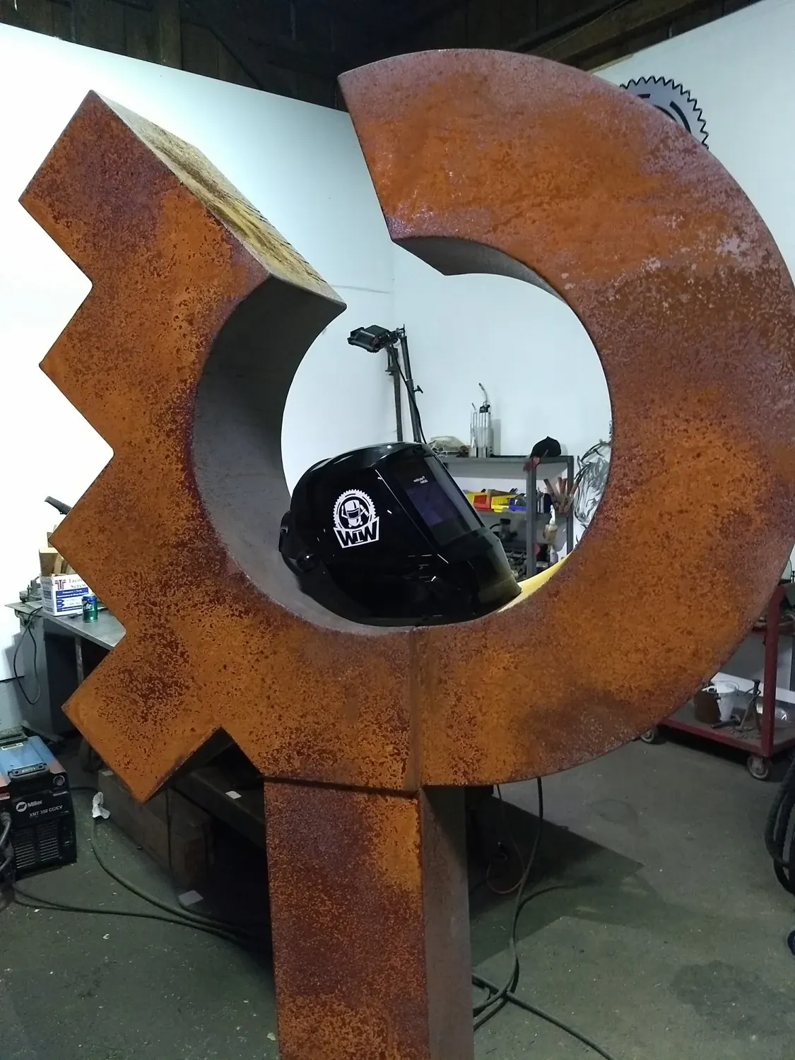 Close view of the rust-colored circular opening, angled steps and deep side surfaces of the shorter sculpture.