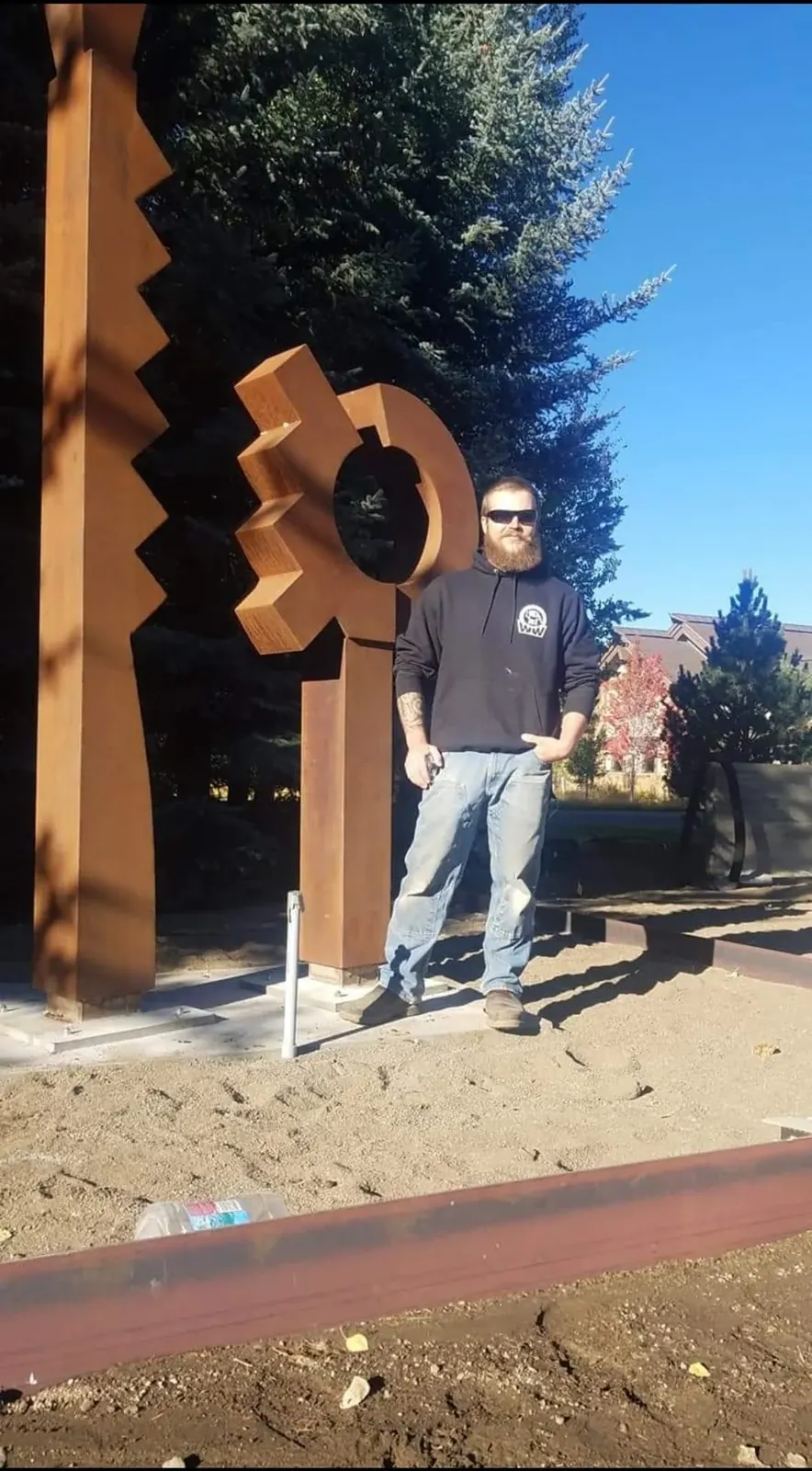 The completed Lee Kelly commission outdoors in Sun Valley, with a person standing beside the circular form for scale.