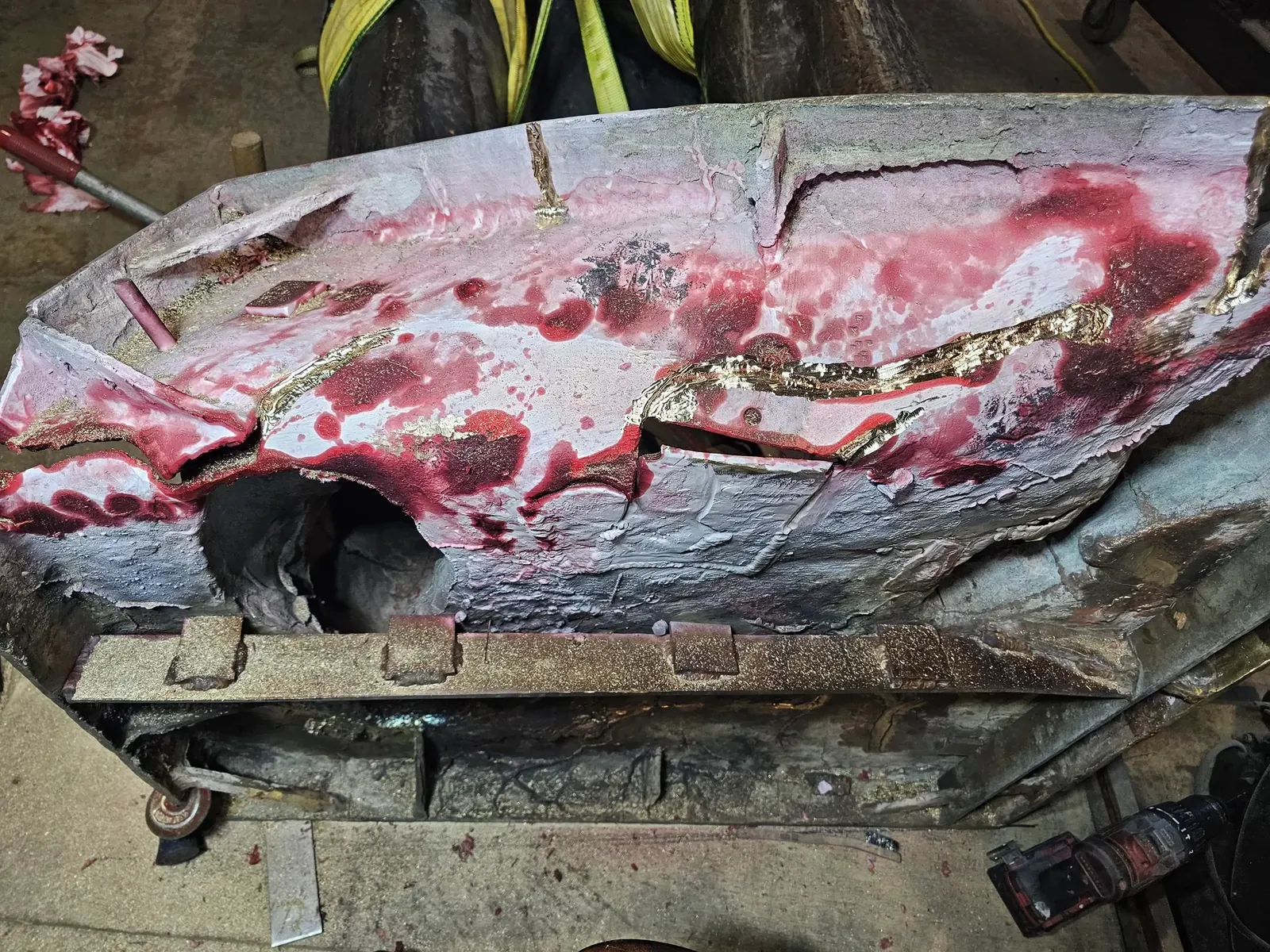 Red and white inspection coating on the underside of the original base, revealing an extensive network of cracks.