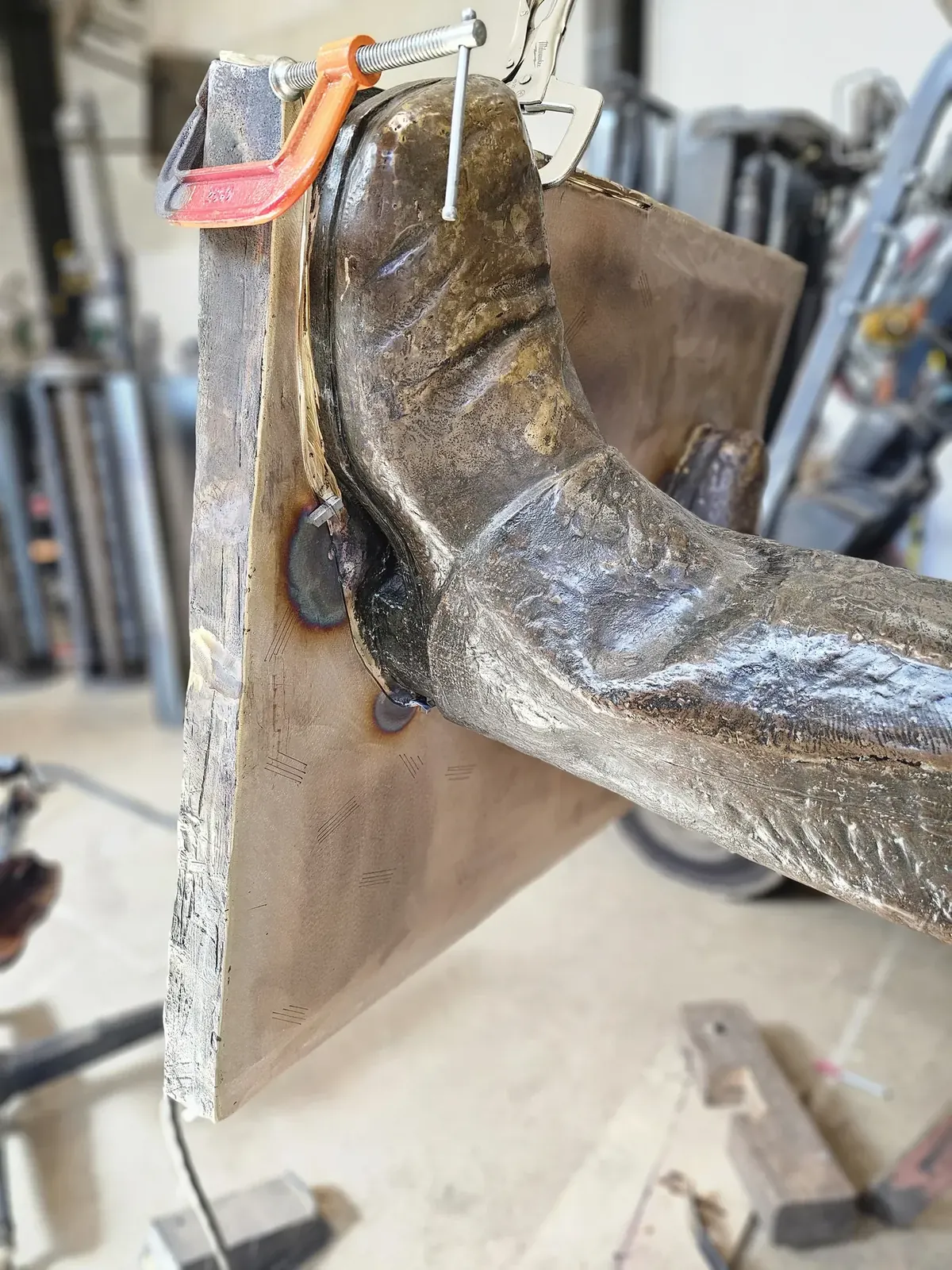 Close view of an original bronze shoe clamped against the new base during fitting.