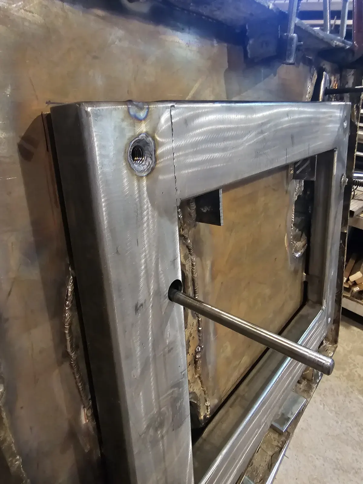 Close view of the fabricated stainless steel frame fitted beneath the replacement base during assembly.