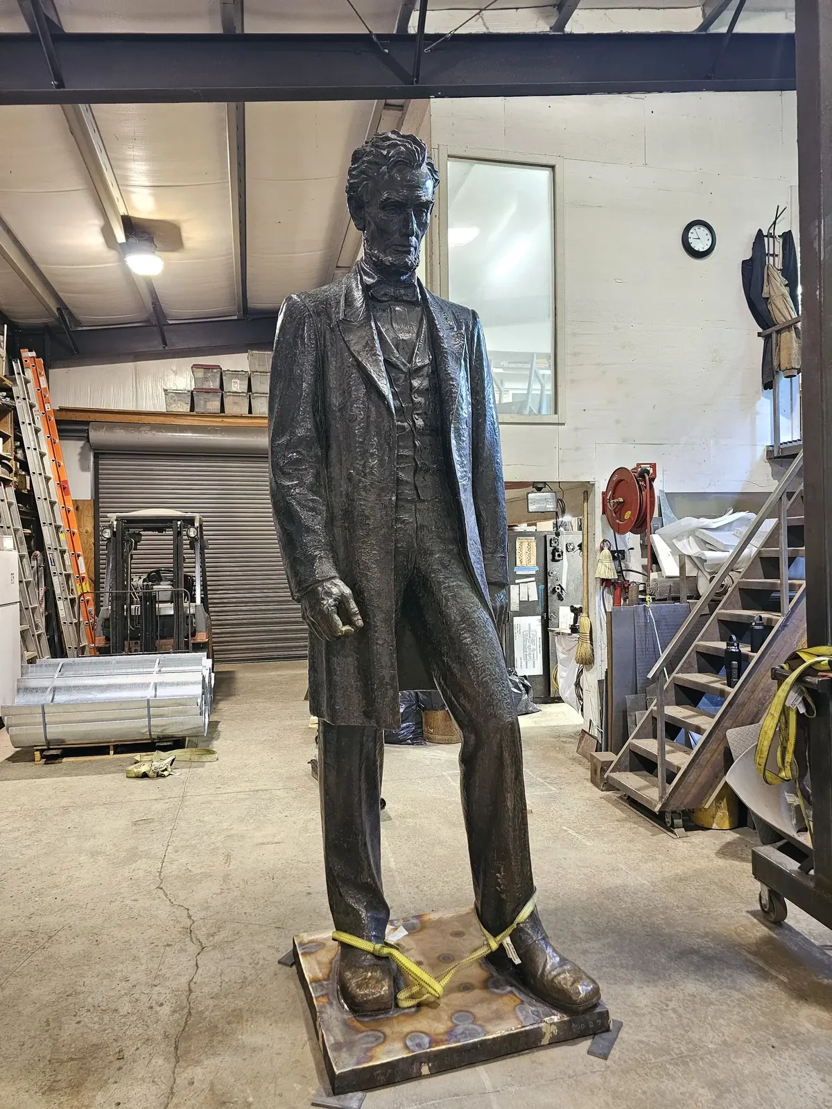 The full Abraham Lincoln statue standing upright on its replacement base in the Western Iron Works shop.
