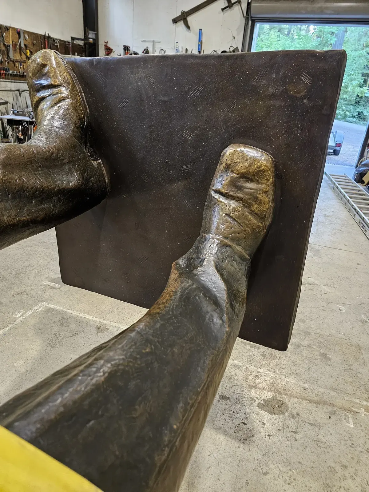 Completed upper surface of the rebuilt base around the original bronze feet, with the repaired edges finished.