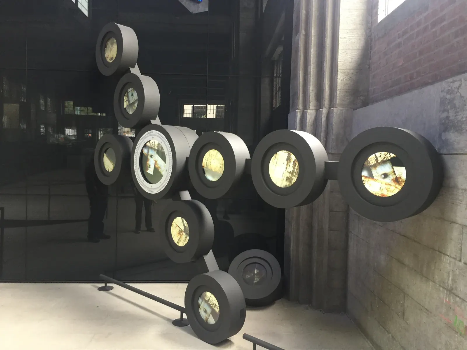 Mechanism in July 2017 with several circular displays showing different moving-image scenes.