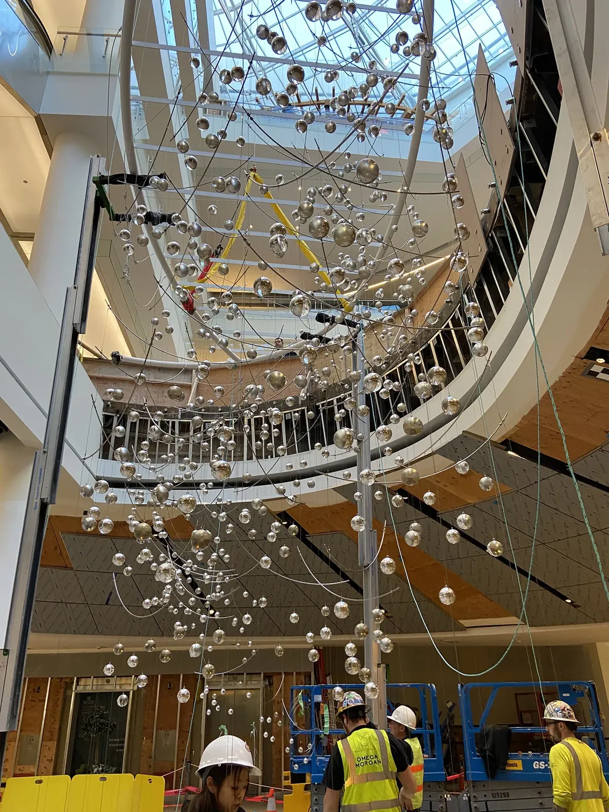 Murmuration hanging in the Pacific Place atrium, with lifts and work areas below.