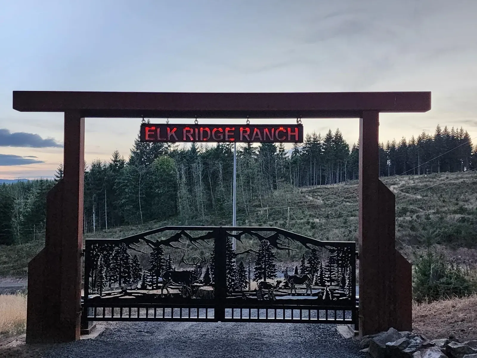Wildlife silhouettes across a paired metal entry gate