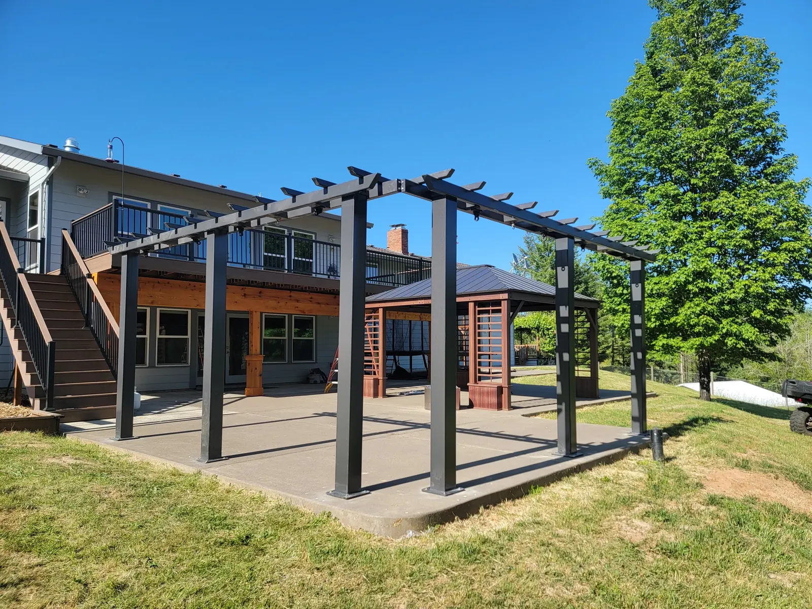 Complete powder-coated steel trellis and swing-set frame beside a house