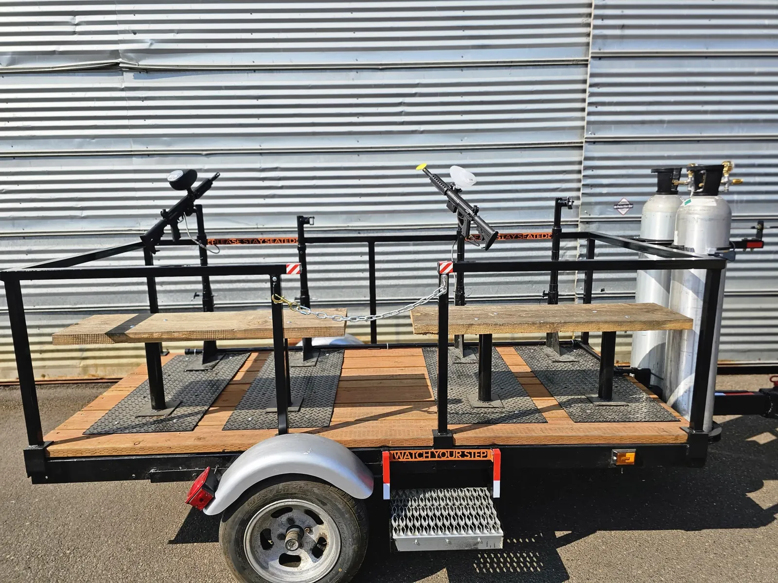 Completed four-seat paintball trailer with benches, mounted paintball guns and two CO₂ tanks