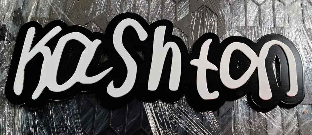 Light Kashton script lettering layered over a dark shaped backing