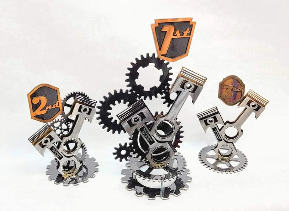 Three custom metal awards with pistons, gears and first-, second- and third-place markers