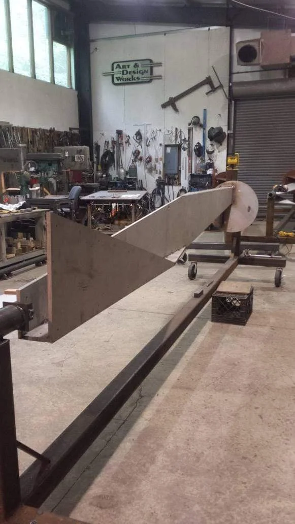 A long metal section taking shape in the shop.