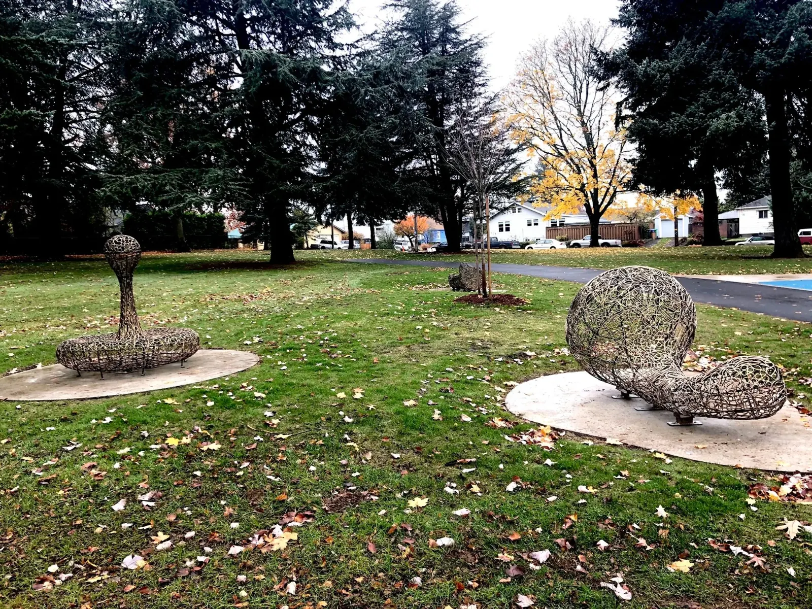 Water and Food, part of Sustenance, on separate concrete pads beneath trees at Glenhaven Park.