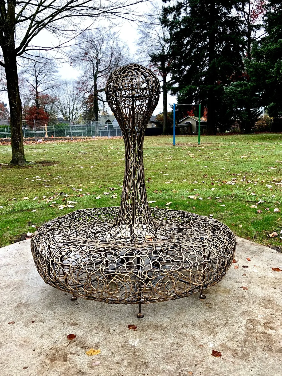 The complete bronze Water sculpture, with a tall droplet rising above a round seat.