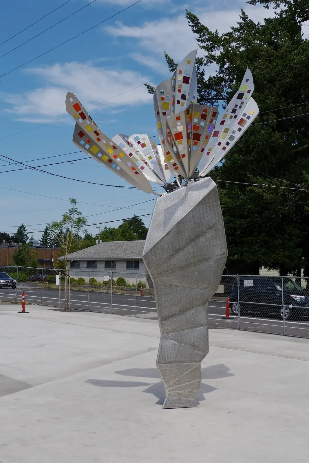 Full daytime view of The Fifth Wind at Gateway Discovery Park, showing the stainless steel wings and tapered base.