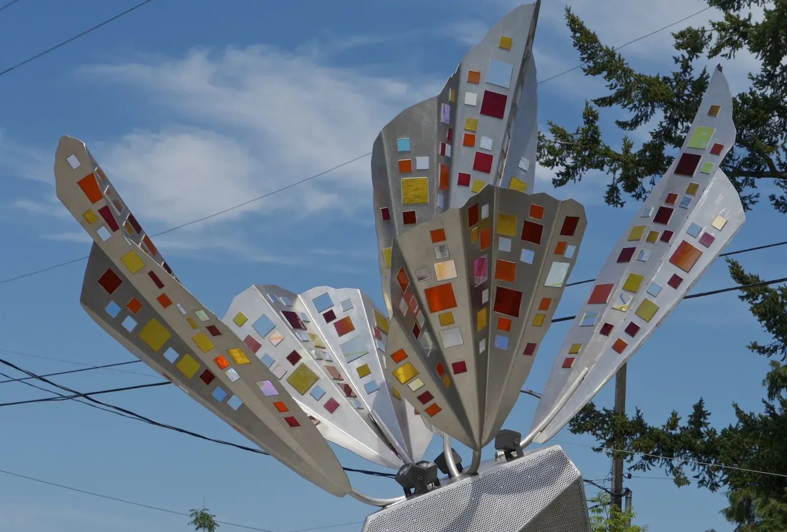 Close view of the five stainless steel butterfly wings, colored glass inserts, and curved supports.