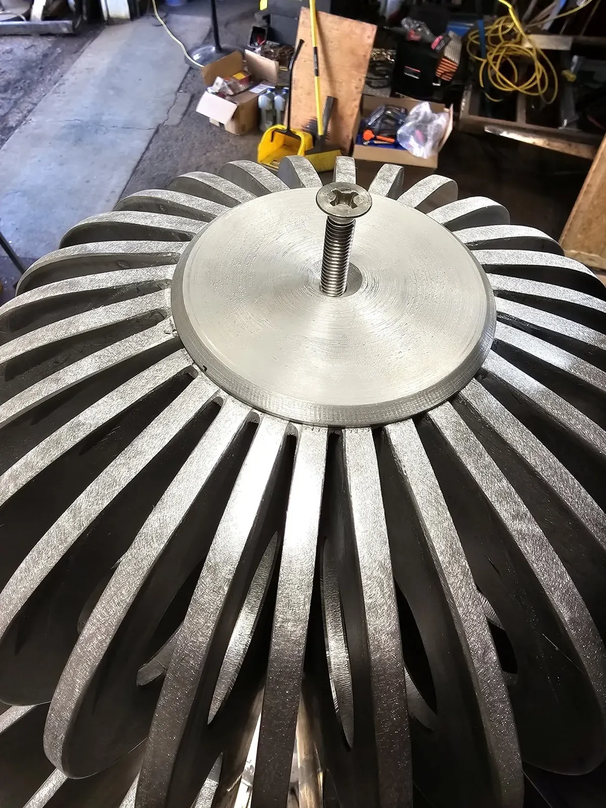 Close view from above of aluminum fins arranged radially around a circular plate and central bolt.