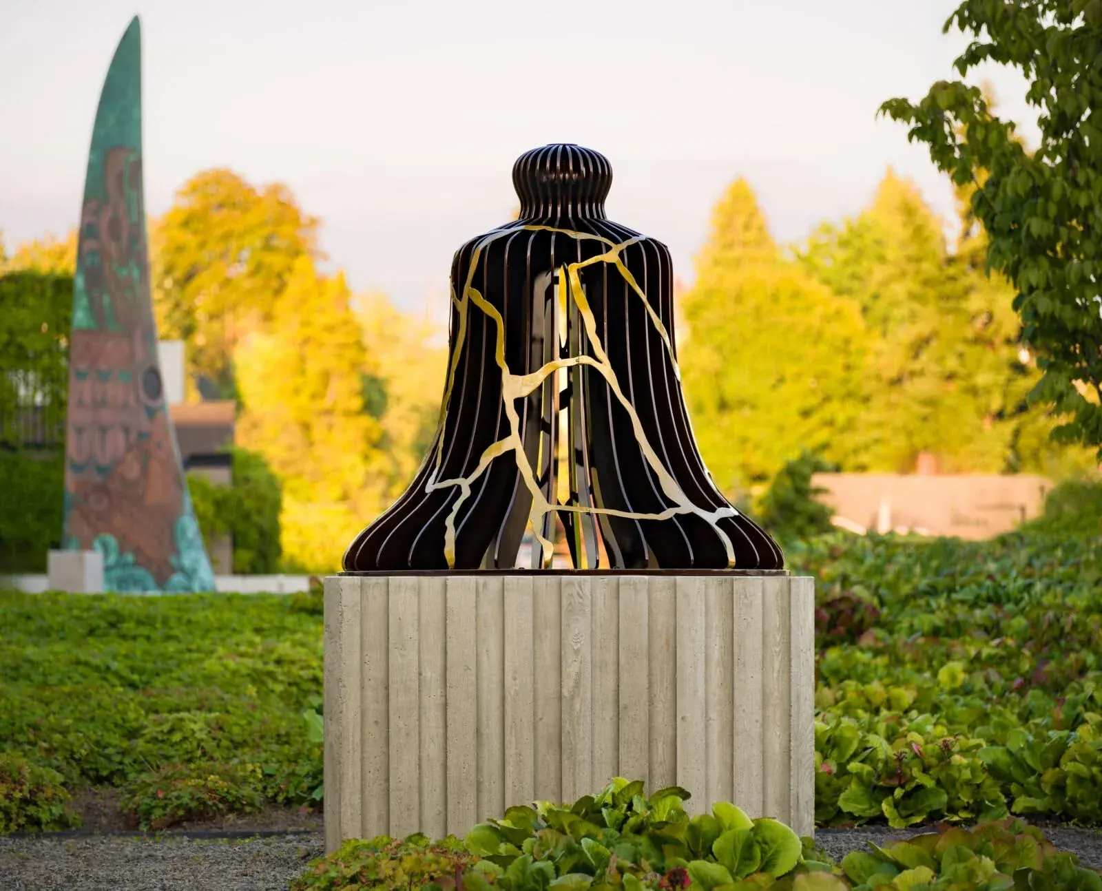 Finished black bell with branching gold-colored metal lines around its outer surface.