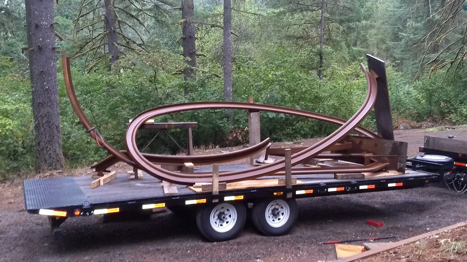 Curved steel sections secured on the trailer.