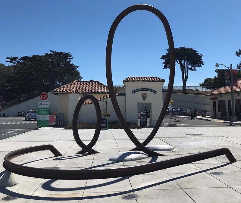 Daylight view of the two steel loops and low sweeping rail outside Fort Mason.