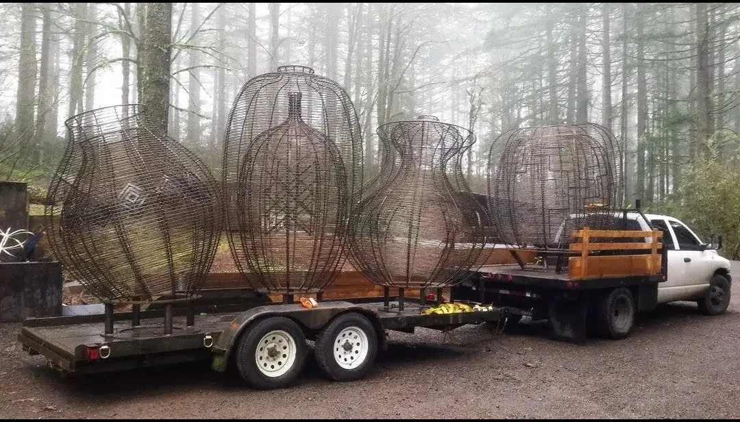 All four completed steel basket forms secured on a trailer and flatbed truck, showing their different outlines and scale.